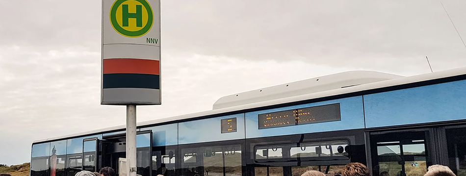 Bushaltestelle mit vielen Menschen die in den Bus steigen